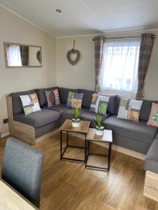 a living room with a couch and two tables at Hughes Holiday Home in St Osyths in Jaywick Sands