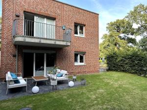 una casa in mattoni con due sedie e un tavolo nel cortile di Alstertraum mit Garten und priv. Wasserzugang ad Amburgo