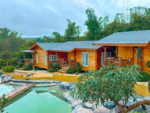 a log cabin with a pond in front of it at Soundless Resort in Khao Kho