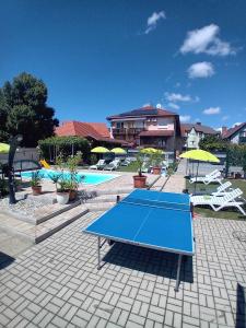 una mesa de ping pong azul frente a una piscina en Ács Apartman, en Hévíz