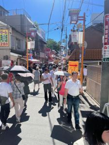 un gruppo di persone che camminano per strada con gli ombrelloni di Naos House Osaka 4 New Open 一軒家貸切 ad Osaka