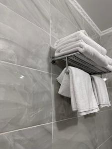 garść ręczników wiszących na wieszaku w łazience w obiekcie Maestro w mieście Ostroh