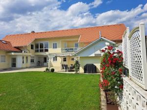 dom z białym płotem i ogródkiem w obiekcie Appartement Schober w mieście Kukmirn