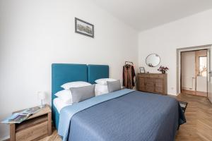 1 dormitorio con cama azul y manta azul en Prague - Karlin Apartments, en Praga