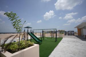 a playground on the roof of a building with green grass at Erwanos Crib 2 Bedroom Condo with Balcony in Naga