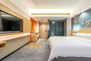 a bedroom with a large bed and a flat screen tv at WAIFIDEN Hotel -Former Tokai Hotel in Guangzhou