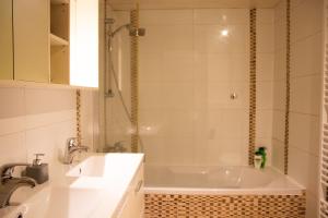 a bathroom with a tub and a sink and a shower at Archimede Guest House in Brussels