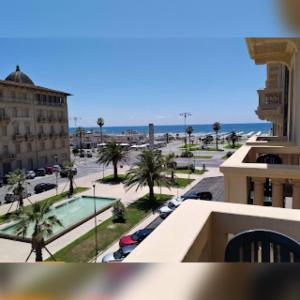 a view of a city with a parking lot and the ocean at Viareggio live in Top deco in Viareggio +7 photos