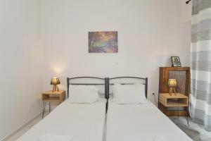 a bedroom with a bed with two night stands and two lamps at Solonos Vibe in Athens
