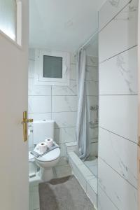 a white bathroom with a toilet and a shower at Solonos Vibe in Athens