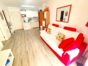 salon z białą kanapą i czerwonymi poduszkami w obiekcie Apartment in Puerto de Santiago. Jardines del Mar w mieście Puerto de Santiago