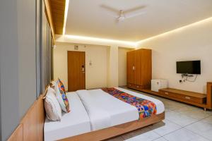 a bedroom with a large bed and a flat screen tv at FabHotel Prime Blue Moon in Gandhinagar