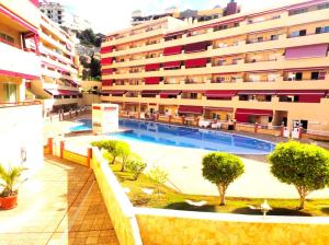 ein Gebäude mit einem Swimmingpool vor einem Gebäude in der Unterkunft Apartment in Puerto de Santiago. Jardines del Mar in Puerto de Santiago