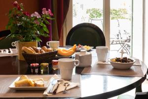 - une table avec une assiette de pain et des fruits dans l'établissement Best Western L'Orangerie, à Nîmes