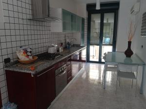 una cocina con encimera y mesa. en camere Olmedo - 10 minuti da Alghero, en Olmedo
