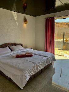 1 dormitorio con 1 cama grande y ventana en Balcony walk rest house Jabal shams, en Sa‘ab Banī Khamīs