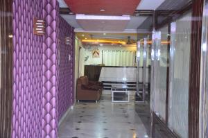 加爾各答的住宿－Hotel Sweet Dream，一个带紫色墙壁的走廊和一个带沙发的房间