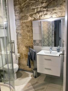 ein Bad mit einem Waschbecken und einem WC in der Unterkunft Immeuble 3 Apparts Centre historique St Gilles MaisoncarreeConciergerie in Saint-Gilles
