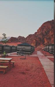 a group of benches and picnic tables in the desert at Wadi rum Rozana camp in Wadi Rum