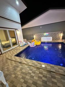 una piscina con una zattera gialla in una casa di GoodDay Poolvilla UdonThani บ้านพูลวิลล่ากู๊ดเดย์ อุดรธานี a Udon Thani