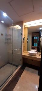 y baño con ducha acristalada y lavamanos. en Bellagio Mansion, en Yakarta