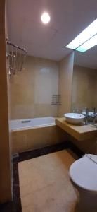 y baño con 2 lavabos, bañera y aseo. en Bellagio Mansion, en Yakarta