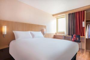- un grand lit blanc dans une chambre d'hôtel dans l'établissement ibis Nantes Centre Gare Sud, à Nantes