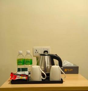 a tea kettle and cups on top of a counter at My Inn Hotel Inanam in Inanam