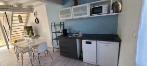 a kitchen with a sink and a table with chairs at L'annexe des Iris in Chaponost