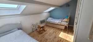 a small attic bedroom with a bed and a window at L'annexe des Iris in Chaponost