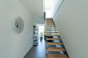 een trap in een huis met witte muren en houten vloeren bij Chalet am Ried in Bad Wurzach