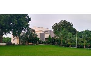a house with a green lawn in front of it at Hotel Hill View, Vadatalav, Gujarat in Hālol