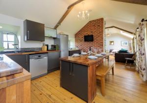 a kitchen and living room with a wooden table in a room at Ty Cam in Aberdaron