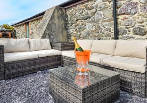 a patio with a couch and a drink on a table at Ty Cam in Aberdaron