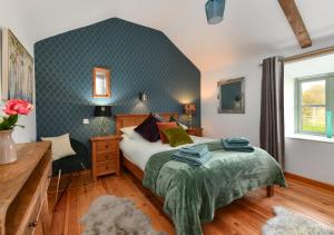 a bedroom with a bed and a chair at Ty Cam in Aberdaron