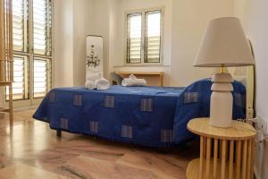 ラメーツィア・テルメにあるAngotti FamilyHouseのランプ付きのドミトリールームの青いベッド1台分です。