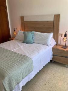 a bedroom with a bed and two lamps on tables at Apartamento Illa de Tambo in Marín