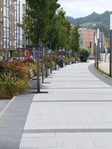 a sidewalk with trees and plants on a city street at Apartamento Illa de Tambo in Marín