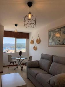 ein Wohnzimmer mit einem Sofa und einem Tisch in der Unterkunft Apartamento Illa de Tambo in Marín