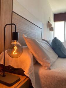 a bedroom with a bed with a lamp on a table at Apartamento Illa de Tambo in Marín