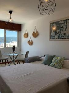 Schlafzimmer mit einem Bett und einem Tisch mit Stühlen in der Unterkunft Apartamento Illa de Tambo in Marín