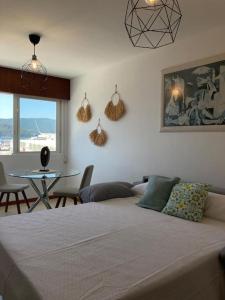 a bedroom with a bed and a table with chairs at Apartamento Illa de Tambo in Marín +10 photos