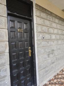 une porte noire avec son numéro dans l'établissement Kiikalloh Grand Resort, à Machakos