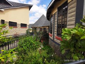 ein Haus mit einem Zaun und einigen Pflanzen in der Unterkunft Kiikalloh Grand Resort in Machakos