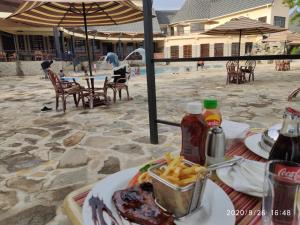 einen Tisch mit einem Teller Essen und Pommes frites in der Unterkunft Kiikalloh Grand Resort in Machakos