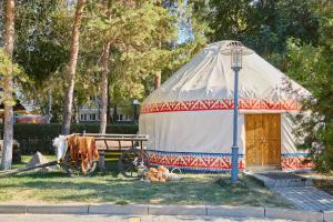 een yurt met een houten deur en een berg groenten bij Saraishyq Hotel in Alma-Ata