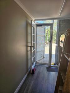 a room with a door open to a room with wood floors at Almost Off Grid Tranquillity in Katherine