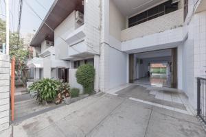 an external view of a white building with a courtyard at RedDoorz Syariah near Taman Kota Kuningan in Kuningan