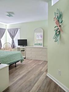 a bedroom with a bed and a dresser with a television at 3B2FB Blissful Surfside Life a peaceful quiet getaway 25 years old and Up ONLY in Myrtle Beach