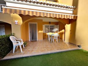une terrasse avec des chaises et une table dans une maison dans l'établissement Casa adosada junto a la playa de El Perelló, à Sueca